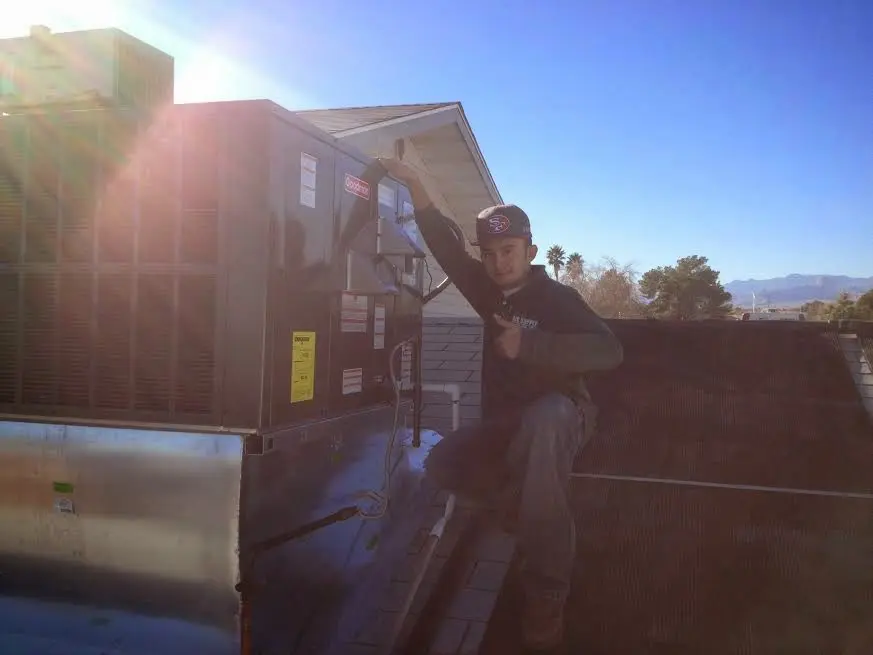 HVAC technician performing HVAC Inspection on a rooftop unit in Socorro